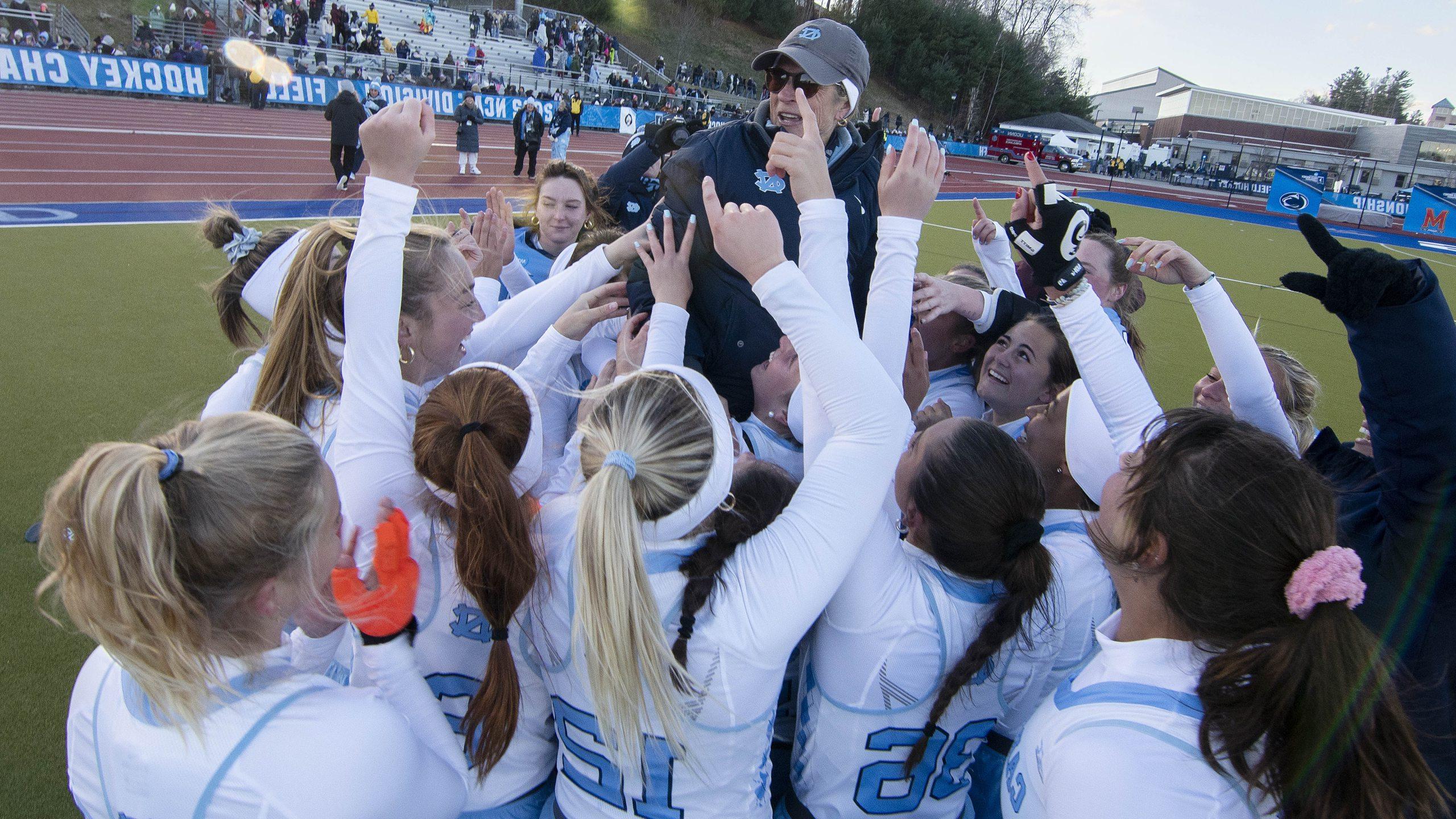 The UNC field hockey team and then-coach Karen Shelton huddled and celebrating a national championship.