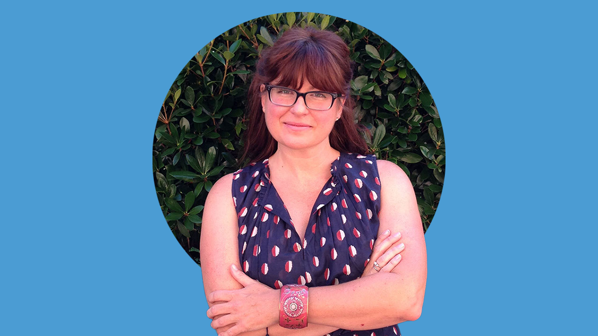 Portrait of Heather Wasser with her arms crossed. The photo is atop a Carolina Blue background.