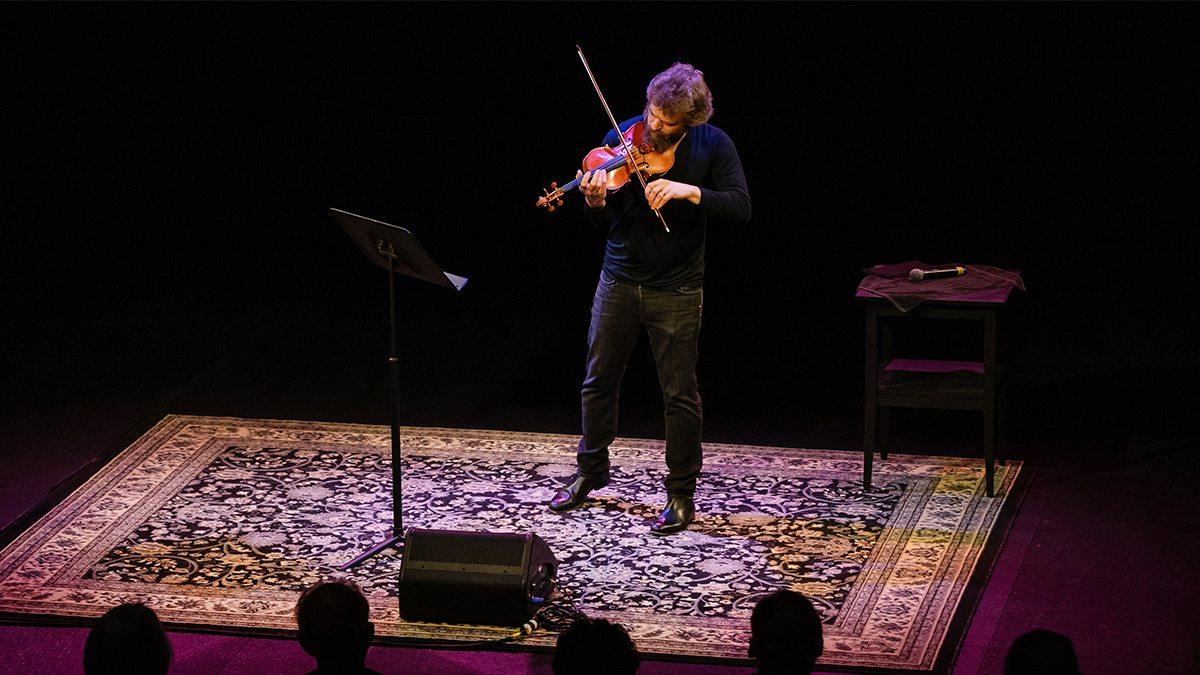 Johnny Gandeslman plays his violin in front of an audience.